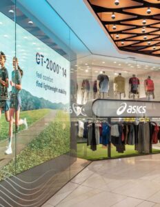 Asics store interior with athletic apparel display, GT-2000™ 14 promotional image highlighting comfort and stability.