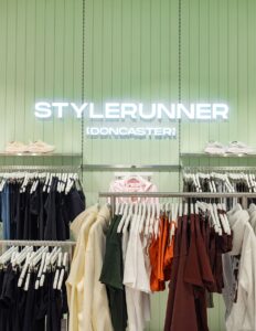 "Stylish clothing display at Stylerunner Doncaster store with colorful shirts and shoes."