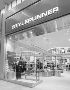 "Stylish storefront of Stylerunner clothing store with fashion displays and apparel inside mall setting."